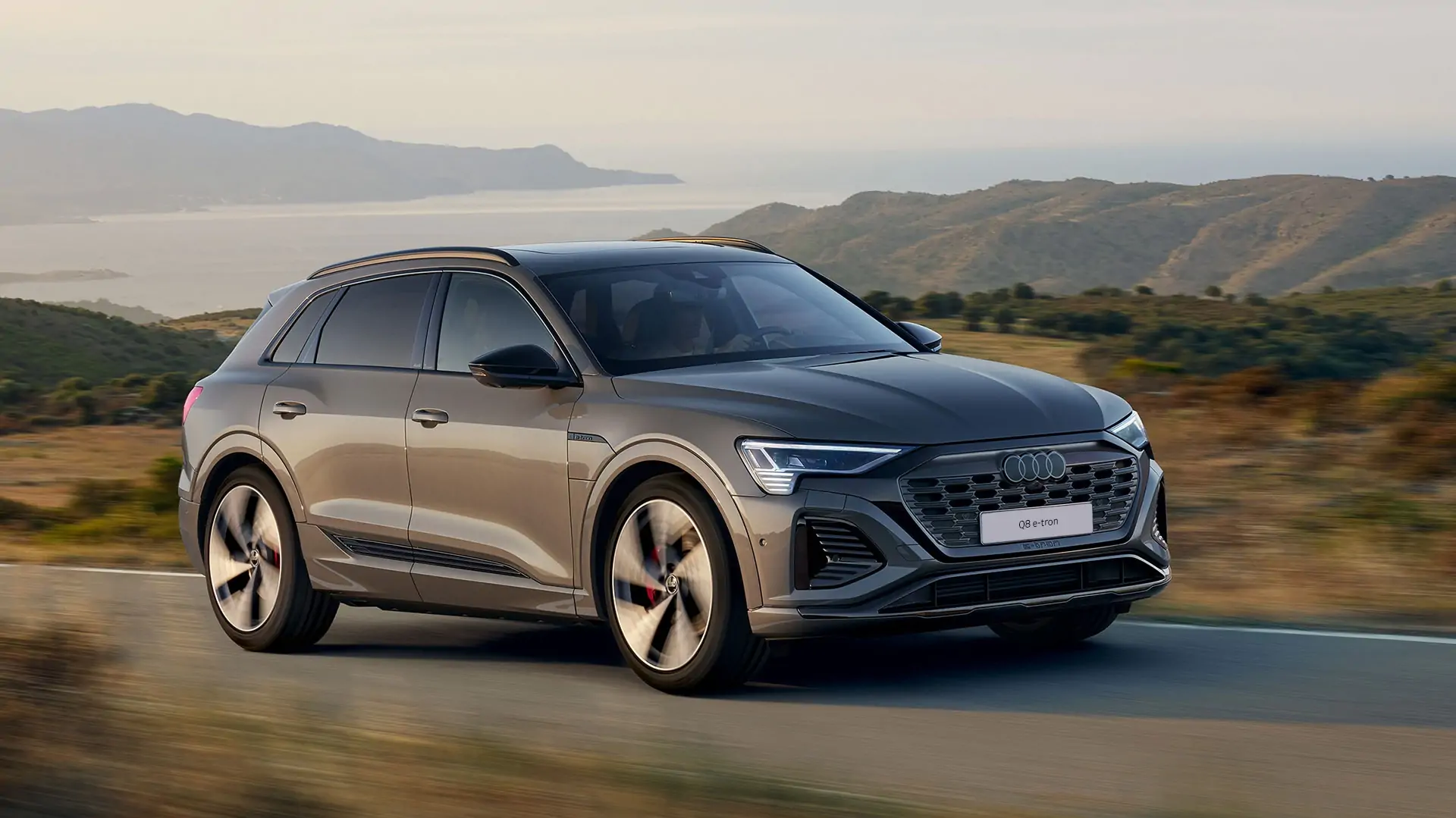 Audi Q8 e-tron v tmavě šedé barvě zachycené v pohybu na dálnici